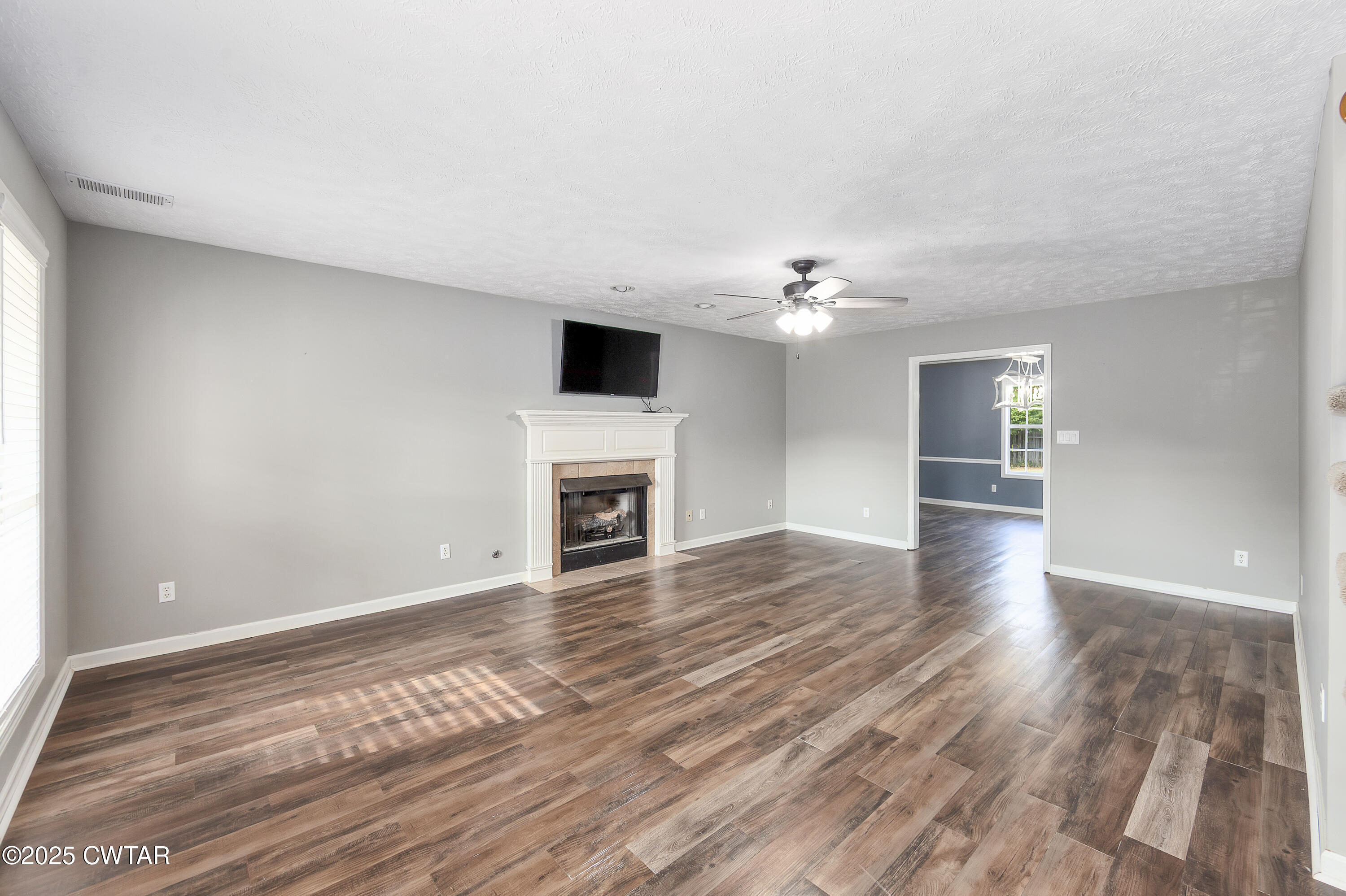175 Willow Branch Drive Jackson, TN 38305 - Photo 8 of 39 a view of an empty room with wooden floor and a fireplace