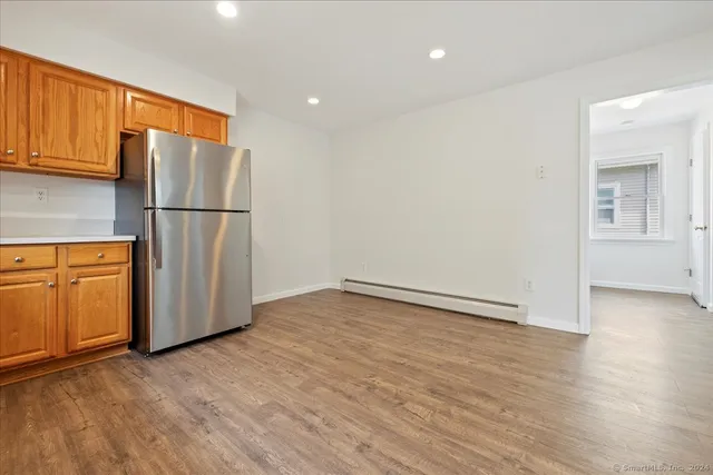 a view of empty room with wooden floor and cabinets