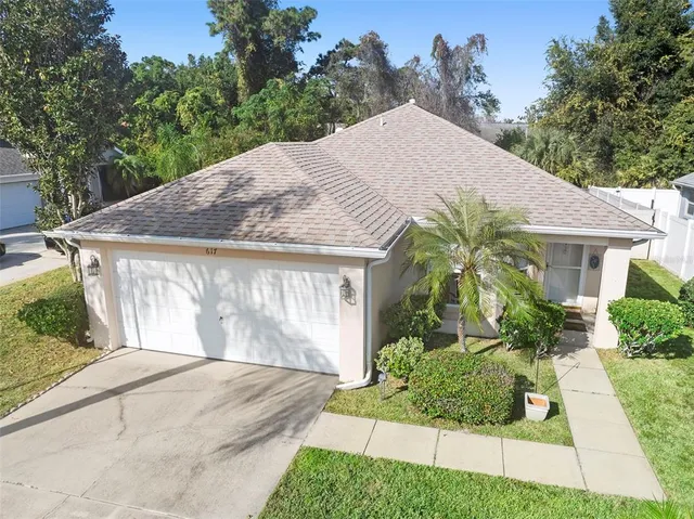 a front view of a house with a yard and potted plants