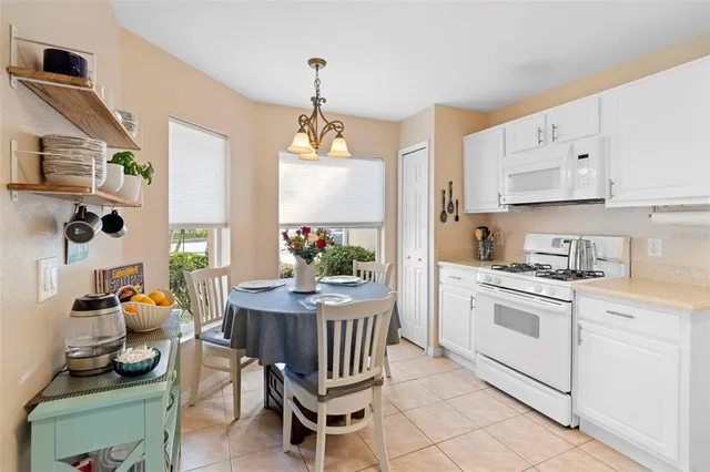 a kitchen with stainless steel appliances kitchen island granite countertop a refrigerator a sink dishwasher and white cabinets with wooden floor