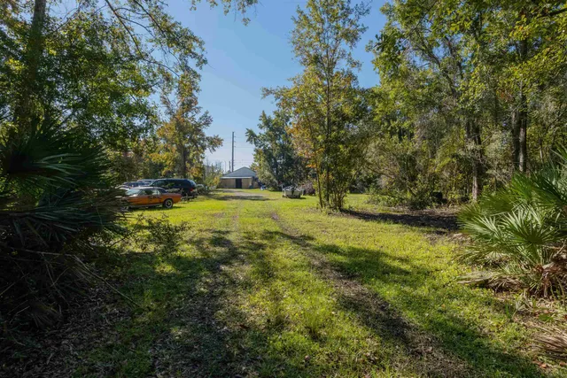 a view of an house with backyard and trees