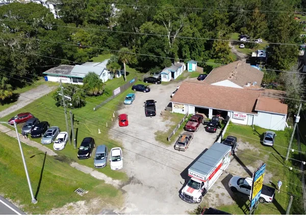 a view of a tennis ground with large trees