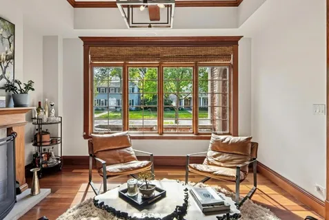 a kitchen with stainless steel appliances kitchen island granite countertop a refrigerator a stove top oven a dining table and chairs with wooden floor