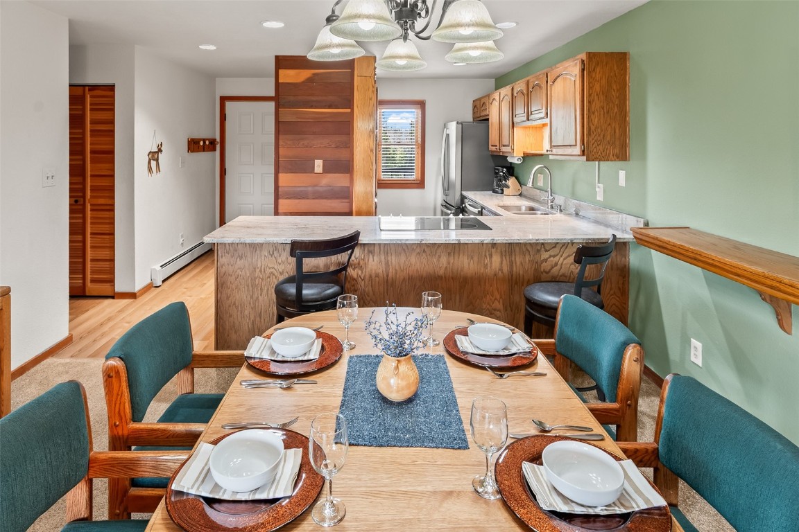 9430 Ryan Gulch Road, Unit 9453 Silverthorne, CO 80498 - Photo 11 of 28 a view of a dining room with furniture a rug and wooden floor
