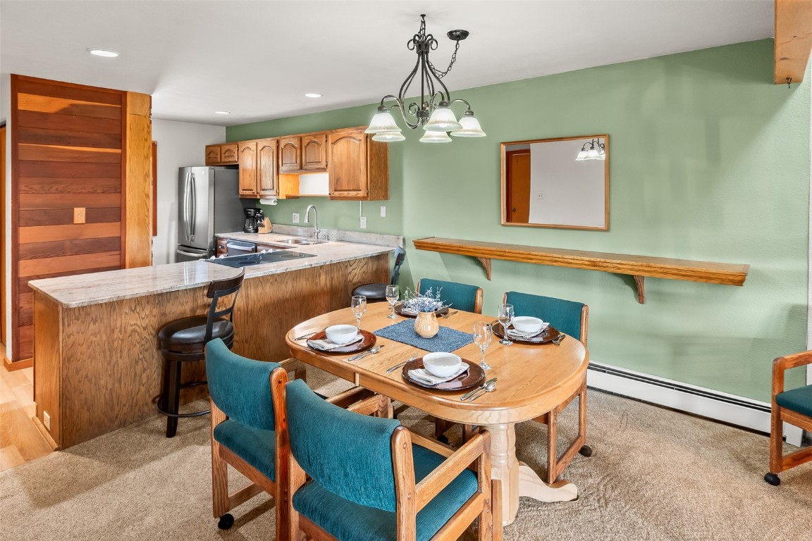 9430 Ryan Gulch Road, Unit 9453 Silverthorne, CO 80498 - Photo 12 of 28 a view of a dining room with furniture and a chandelier