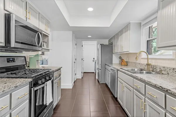 a kitchen with stainless steel appliances granite countertop a sink stove and refrigerator