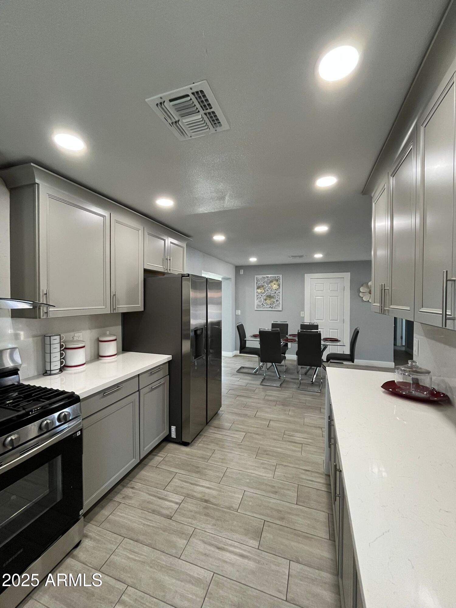 3639 West Lawrence Lane Phoenix, AZ 85051 - Photo 17 of 28 a large kitchen with a large counter top furniture a refrigerator and cabinets