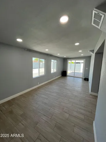 a view of empty room with wooden floor