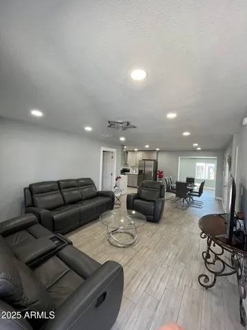 a living room with furniture and a wooden floor