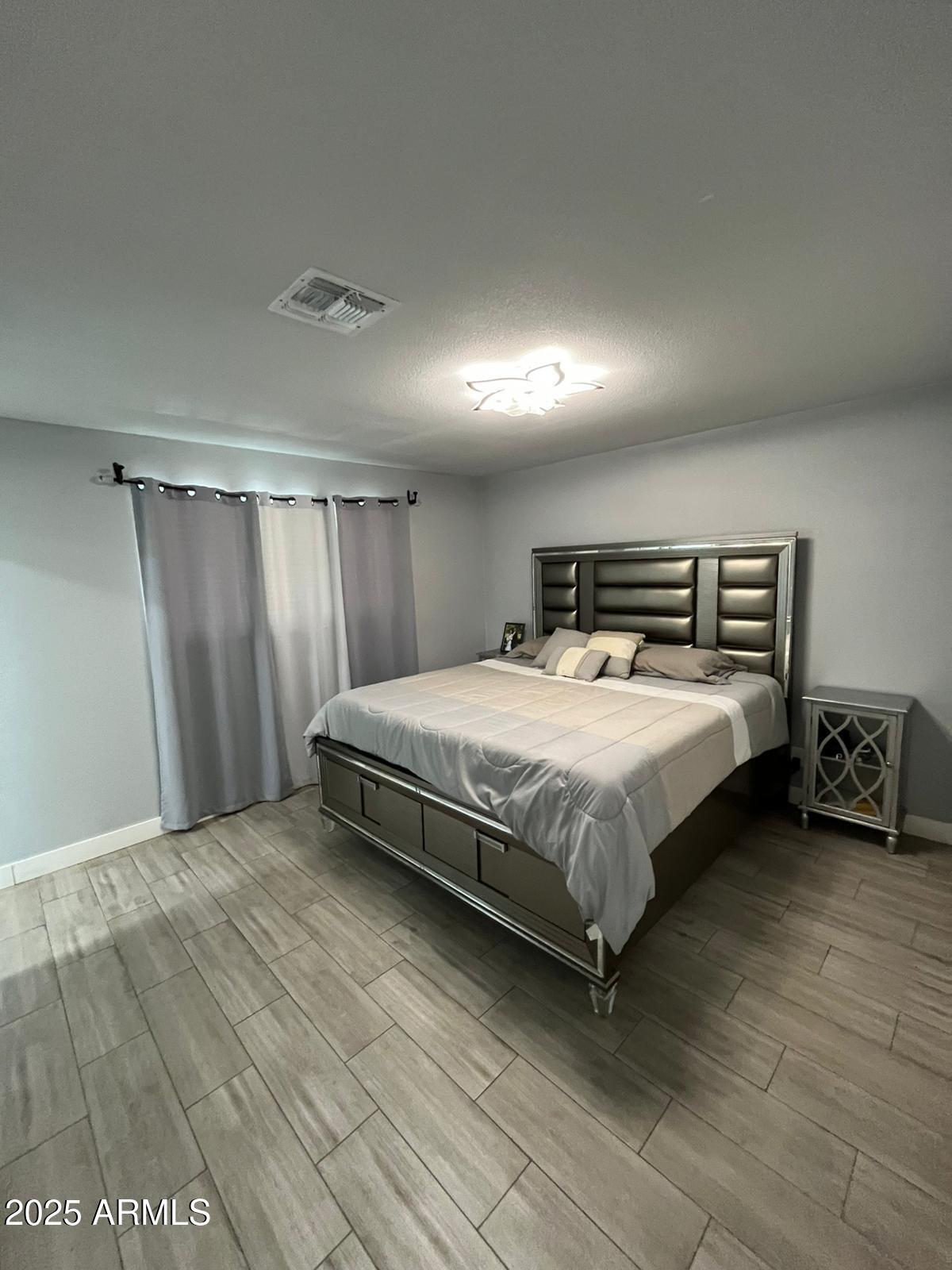 3639 West Lawrence Lane Phoenix, AZ 85051 - Photo 10 of 28 a bed sitting in a spacious bedroom next to a cabinet