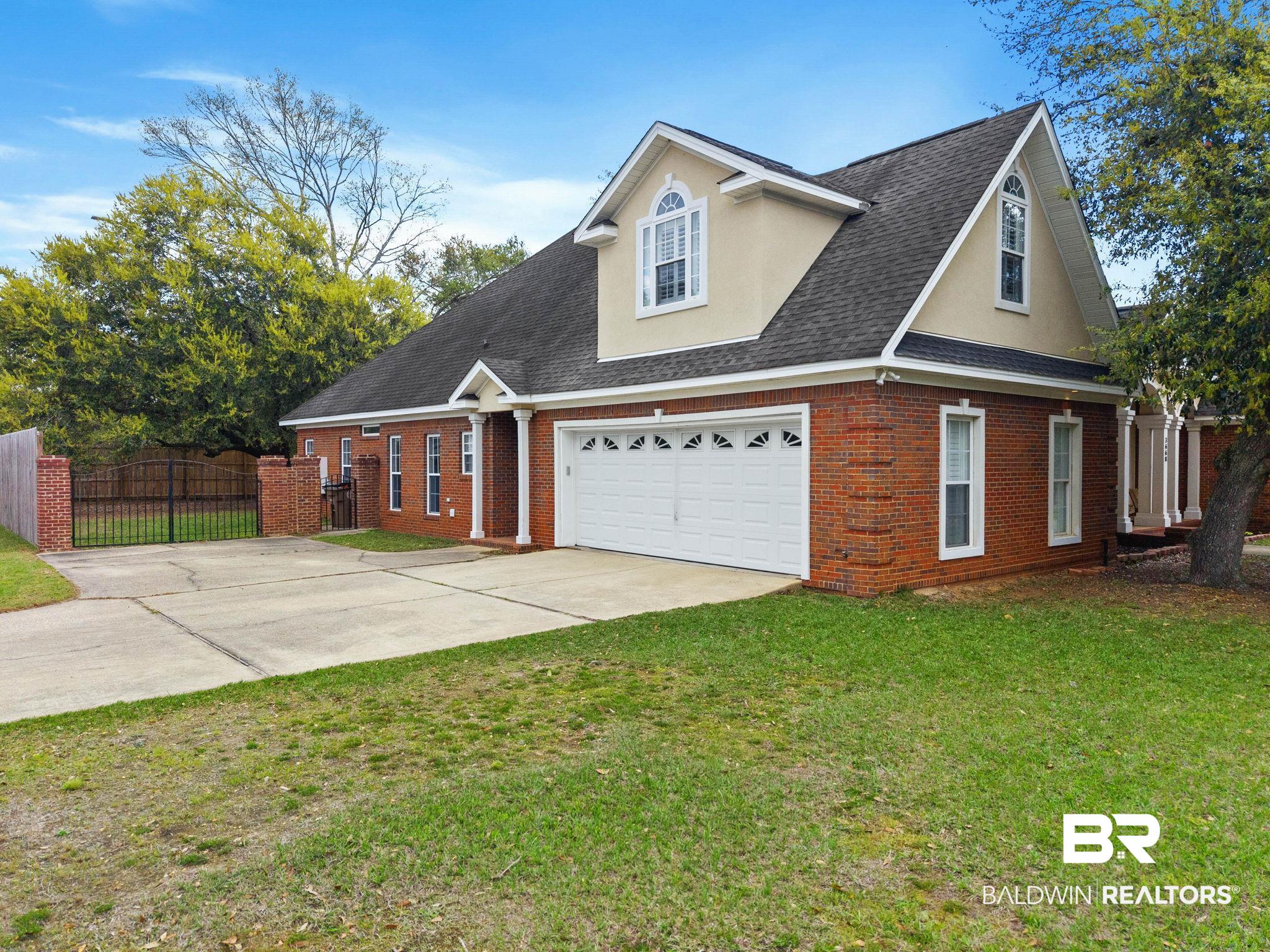 3668 Claridge Road North Mobile, AL 36608 - Photo 12 of 100 View of front facade with brick siding, a shingled roof, concrete driveway, stucco siding, and a gate