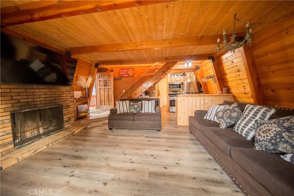 512 Shady Dell Crestline, CA 92325 - Photo 11 of 42 a living room with a couch a fireplace and a flat screen tv