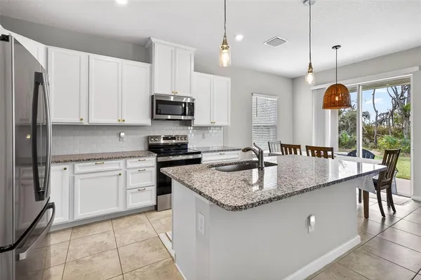 a kitchen with stainless steel appliances granite countertop a sink a stove a microwave and a refrigerator