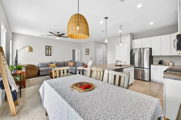 a living room with furniture a rug kitchen view and a table