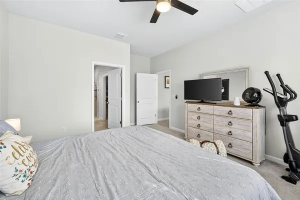 a bedroom with a bed and a flat tv screen on dresser