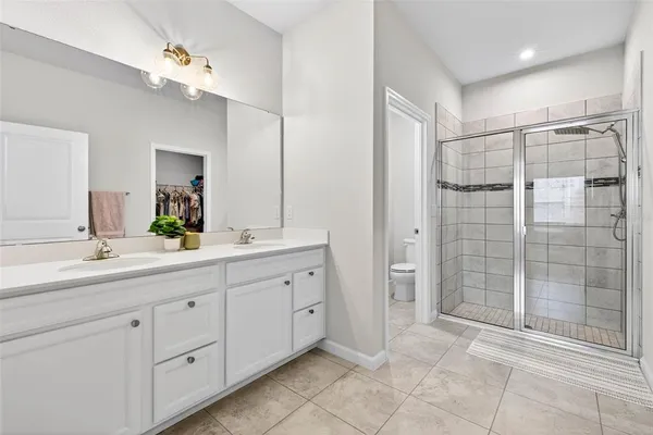 a spacious bathroom with a shower a sink and a mirror