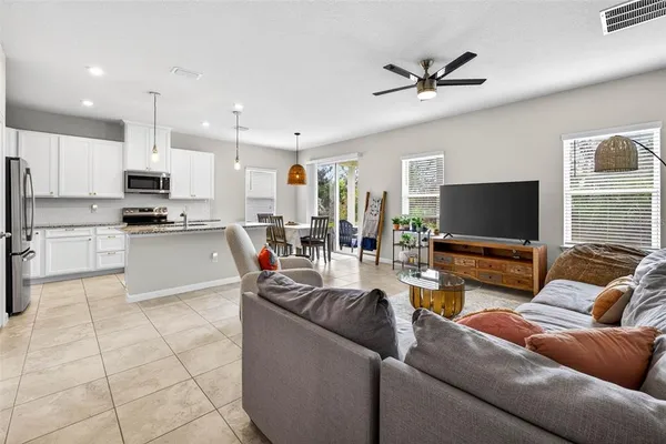 a living room with stainless steel appliances furniture and a view of kitchen