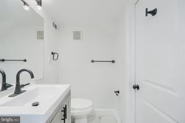 a bathroom with a sink toilet and a mirror