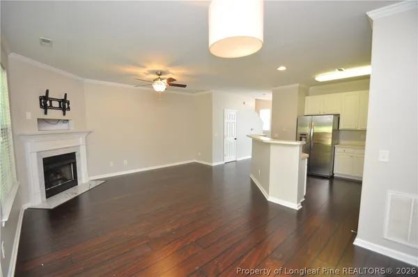 a view of a kitchen with a sink a fireplace a window and wooden floor