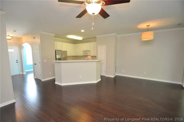 a view of a kitchen with wooden floor and a ceiling fan