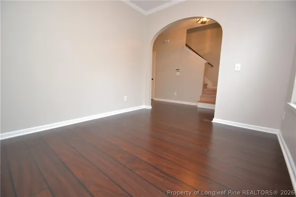 an empty room with wooden floor and mirror