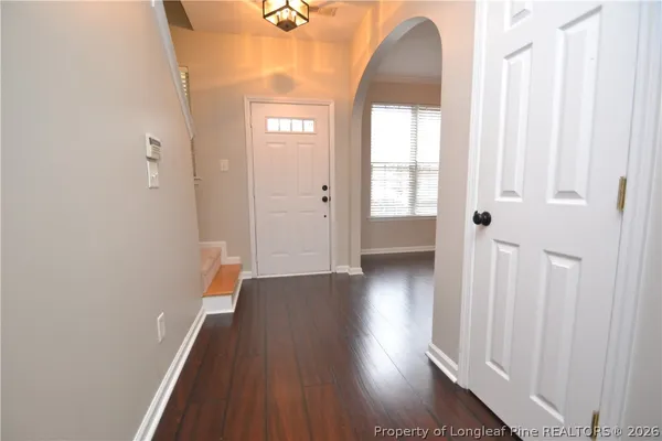 a view of a hallway with wooden floor and stairs