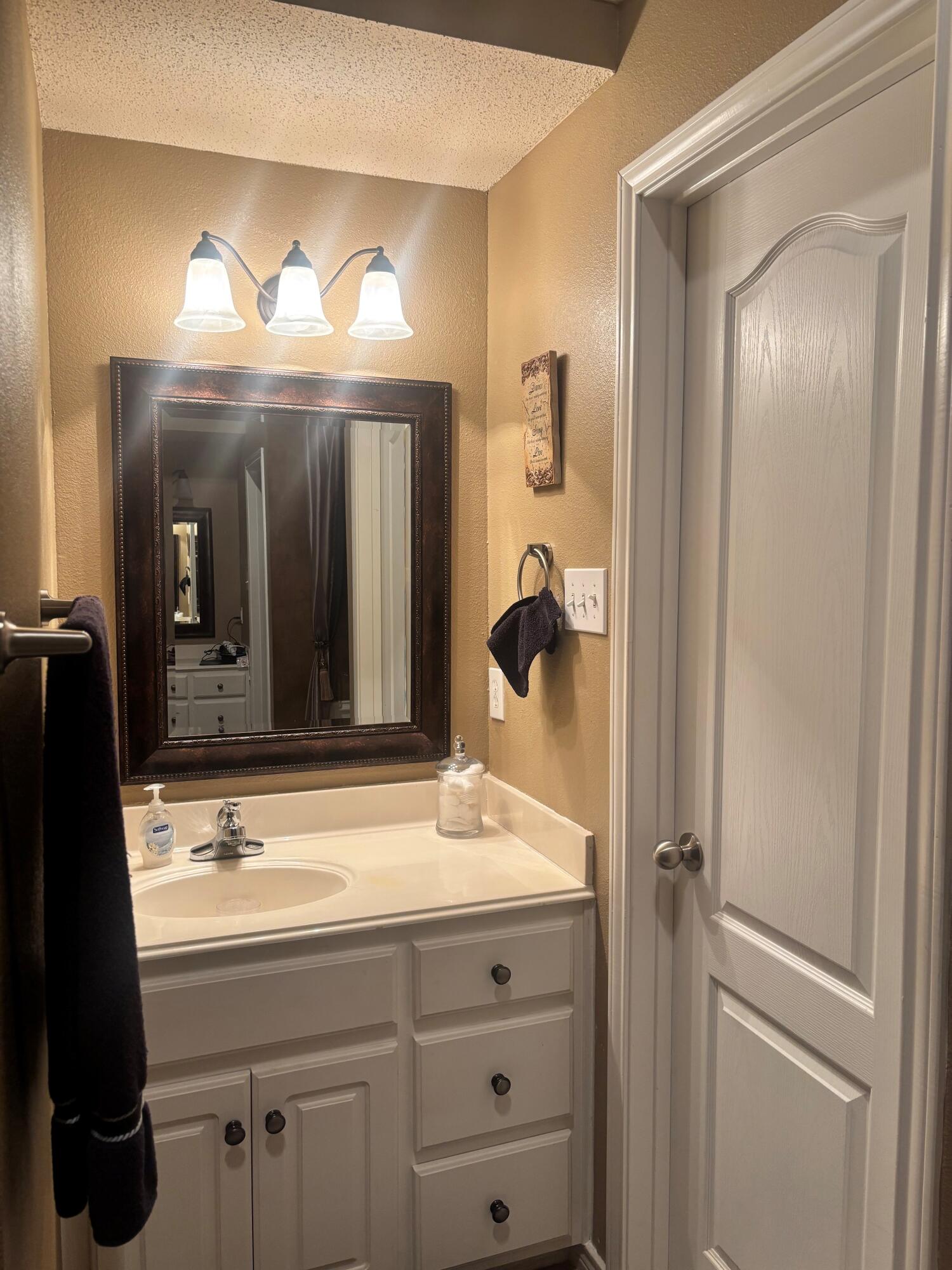 3713 106th Street Lubbock, TX 79423 - Photo 11 of 22 a bathroom with a sink and a mirror