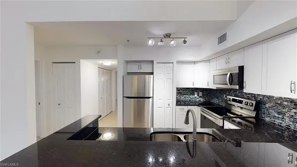 a kitchen with stainless steel appliances a refrigerator and a stove top oven