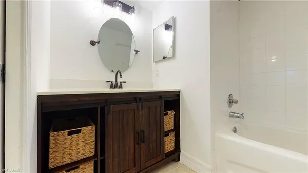 a bathroom with a sink a mirror and bathtub
