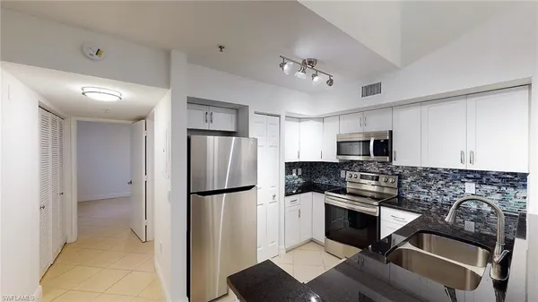 a kitchen with stainless steel appliances granite countertop a refrigerator stove and sink