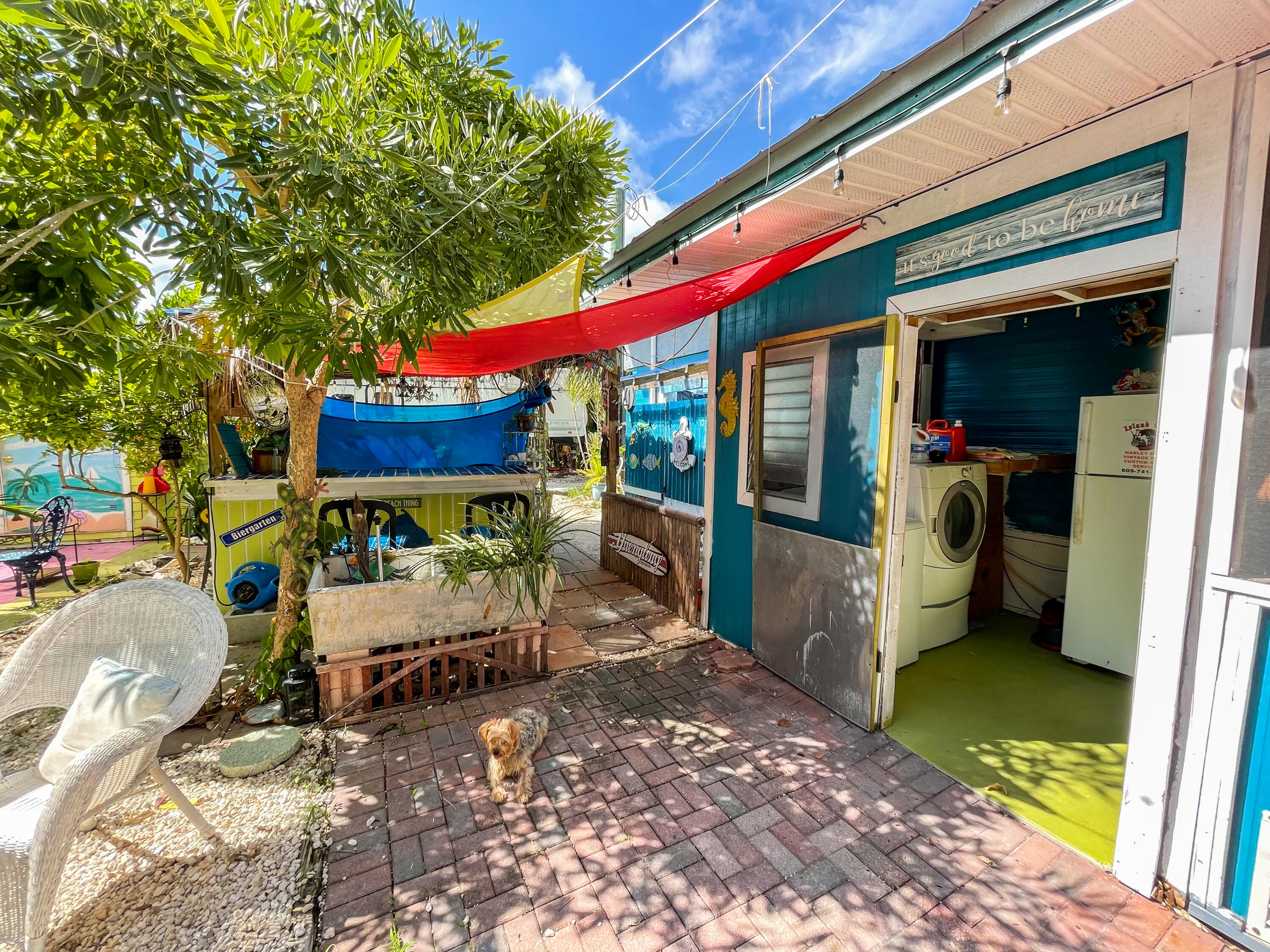 31316 Ave C Big Pine Key, FL 33043 - Photo 14 of 28 a view of a patio with table and chairs potted plants and large tree