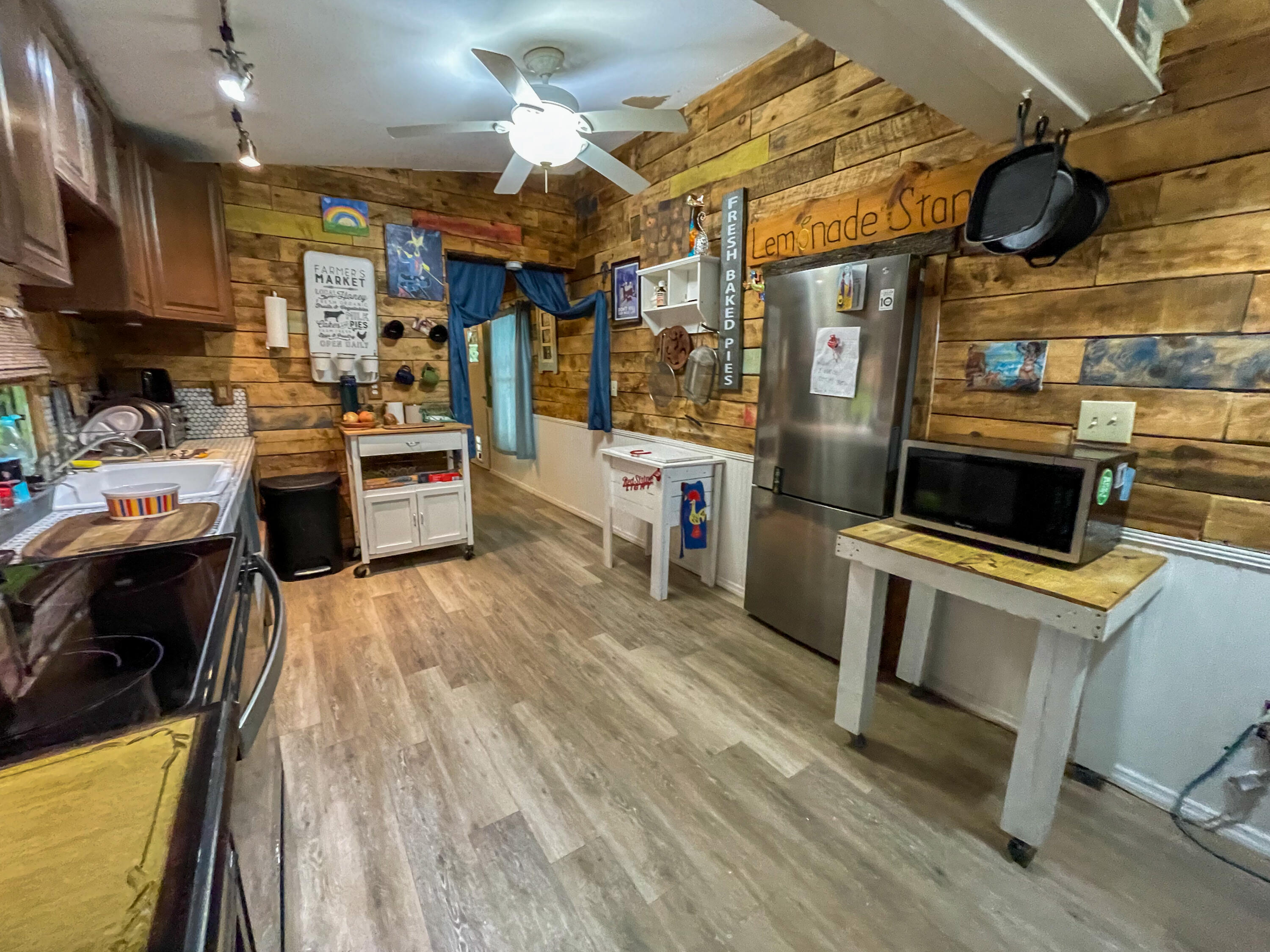 31316 Ave C Big Pine Key, FL 33043 - Photo 23 of 28 a kitchen with a refrigerator a stove top oven a sink dishwasher and wooden cabinets with wooden floor
