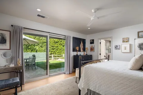 a bedroom with a bed and large windows