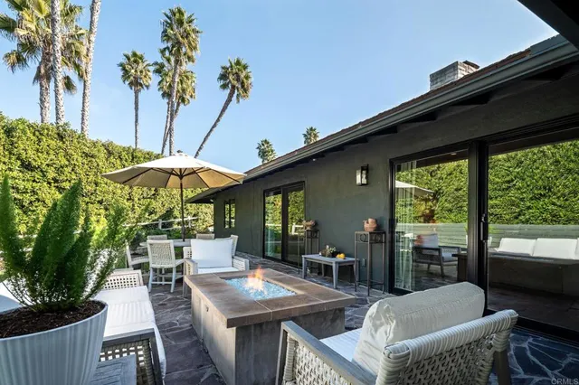 a patio with a table and chairs and potted plants