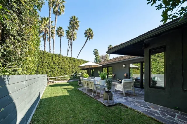 a view of a chair and table in backyard of the house