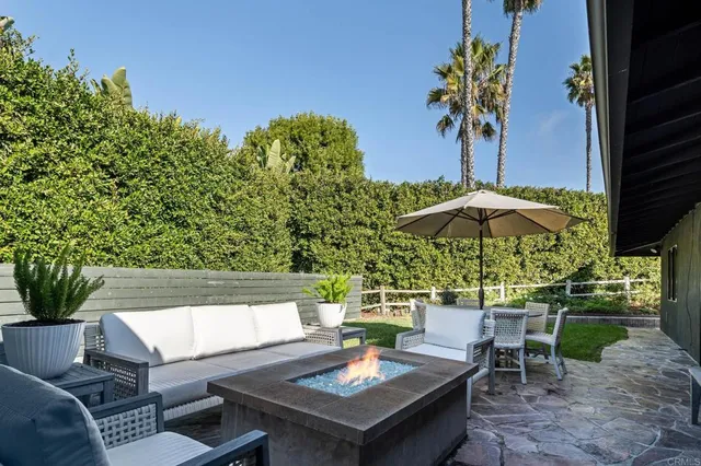 an outdoor sitting area with furniture and umbrella