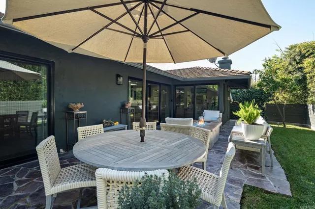 a patio with a table and chairs under an umbrella