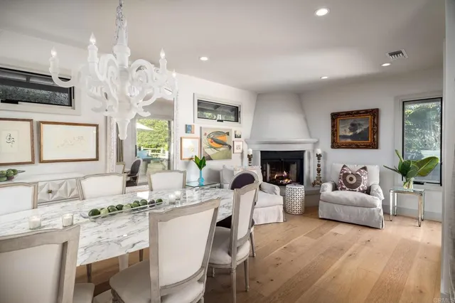 a living room with furniture a fireplace and a chandelier