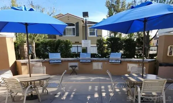 a view of a patio with chairs and umbrellas under an umbrella