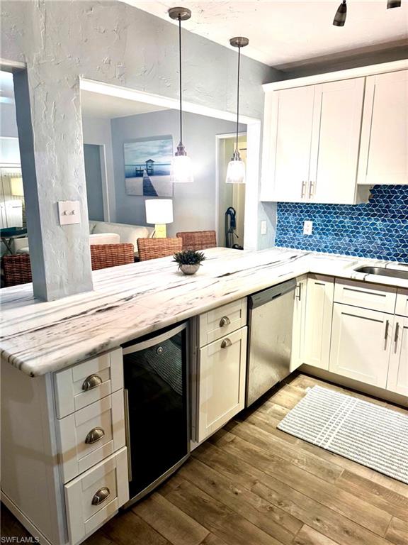 981 8th Terrace North Naples, FL 34102 - Photo 2 of 13 a kitchen with a sink dishwasher a stove and white cabinets with wooden floor