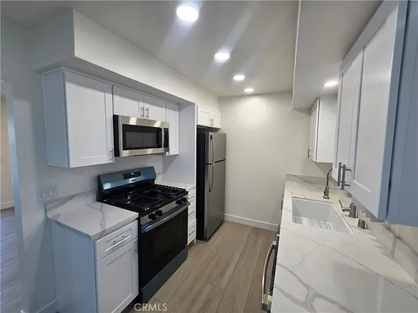 a kitchen that has a sink and a stove top oven