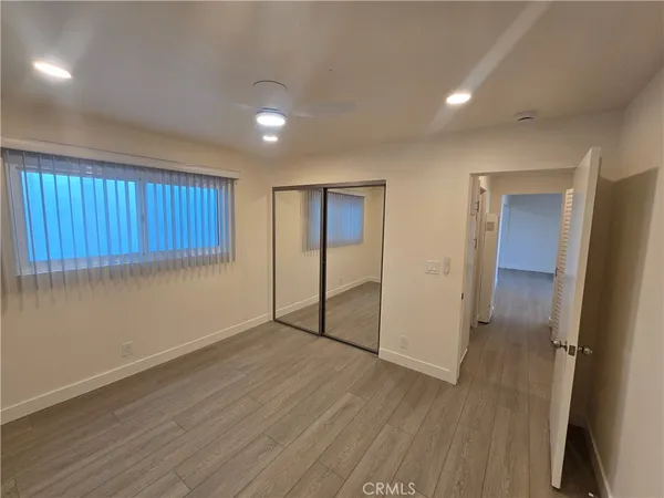 an empty room with wooden floor and a window