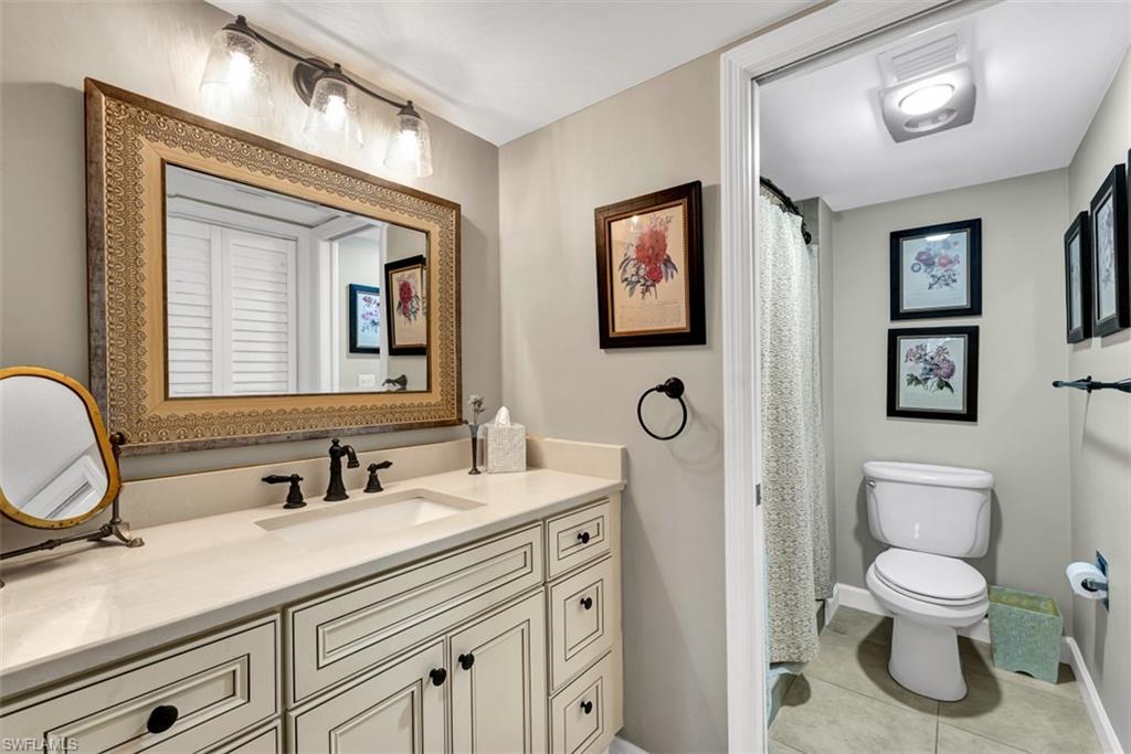 1617 Spoonbill Lane, Unit 1617 Naples, FL 34105 - Photo 13 of 31 a bathroom with a toilet sink and mirror