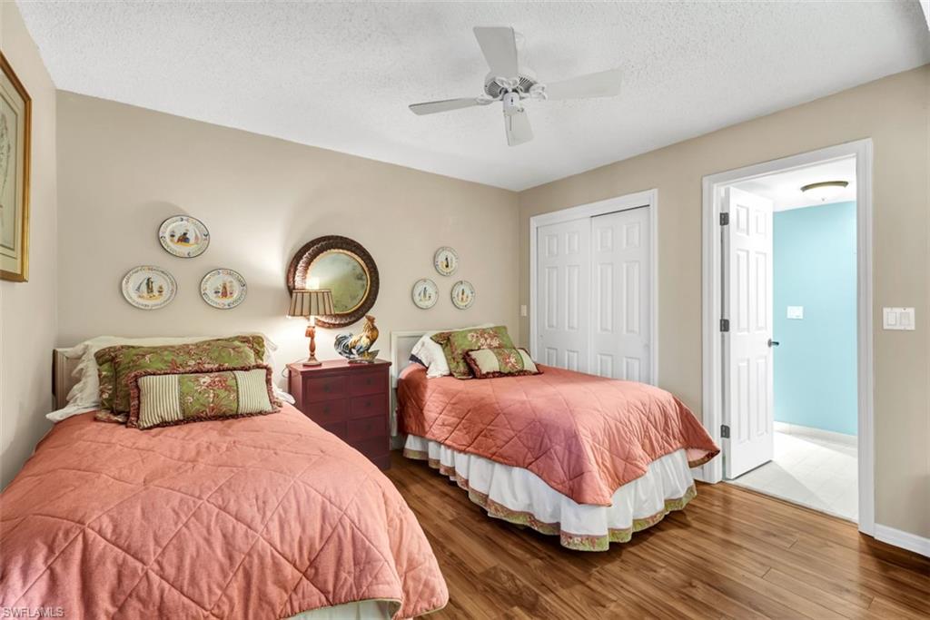 1617 Spoonbill Lane, Unit 1617 Naples, FL 34105 - Photo 14 of 31 a bedroom with two beds and a chandelier