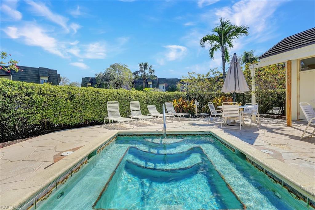 1617 Spoonbill Lane, Unit 1617 Naples, FL 34105 - Photo 20 of 31 a view of a swimming pool with a patio and a yard