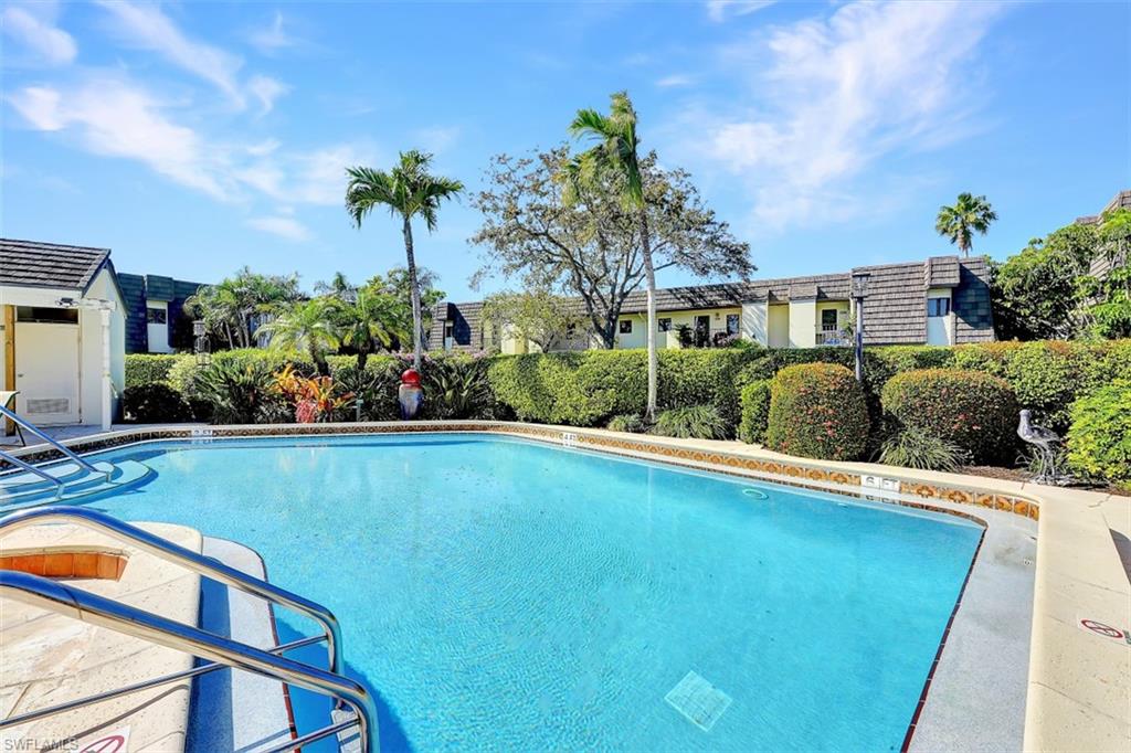 1617 Spoonbill Lane, Unit 1617 Naples, FL 34105 - Photo 21 of 31 a view of a backyard with plants and swimming pool
