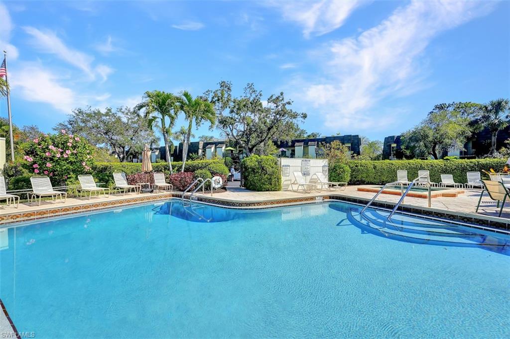 1617 Spoonbill Lane, Unit 1617 Naples, FL 34105 - Photo 23 of 31 a view of a swimming pool with a patio and a yard