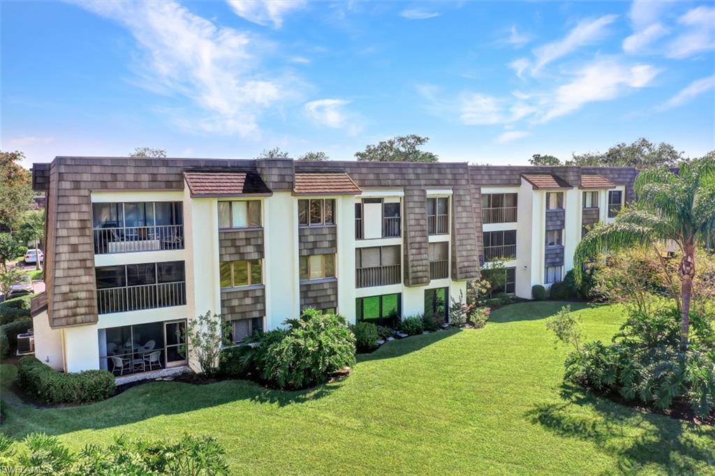 1617 Spoonbill Lane, Unit 1617 Naples, FL 34105 - Photo 30 of 31 a view of a building with a yard