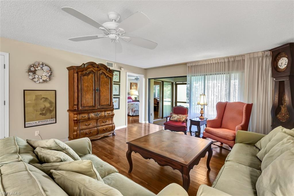 1617 Spoonbill Lane, Unit 1617 Naples, FL 34105 - Photo 3 of 31 a living room with furniture a flat screen tv and a window