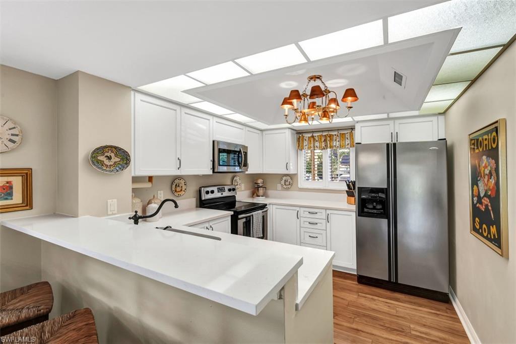 1617 Spoonbill Lane, Unit 1617 Naples, FL 34105 - Photo 4 of 31 a kitchen with a sink a refrigerator and a window